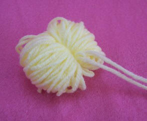 Tie yarn around loops to make a pompom